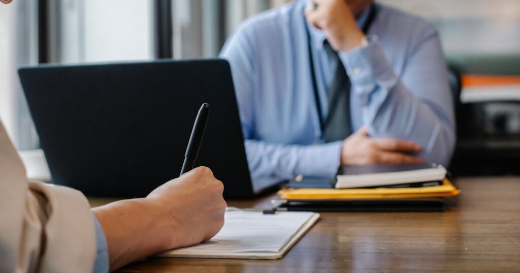 Cliente assinando documentos durante consulta jurídica sobre busca e apreensão de veículo financiado
