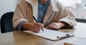 Pessoa assinando documento em cartório representando inventário extrajudicial