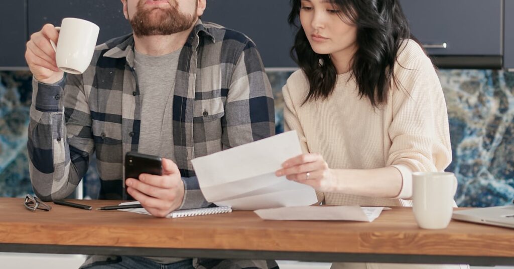 Casal preocupado analisando contas e dívidas em casa