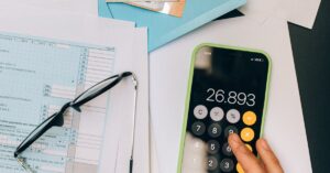 Calculadora e documentos representando análise de juros em contrato bancário