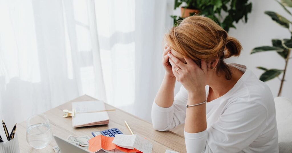 Mulher revisando contas e calculadora simbolizando situação de dívidas e mínimo existencial