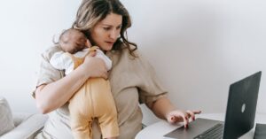 Mãe com bebê consultando notebook representando pensão alimentícia