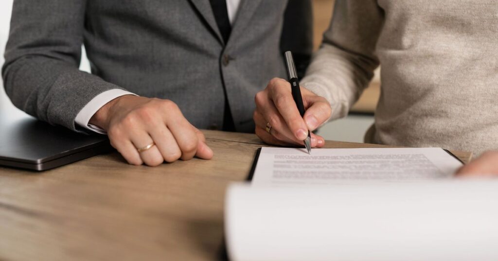 Casal adulto assinando contrato de compra de imóvel na planta