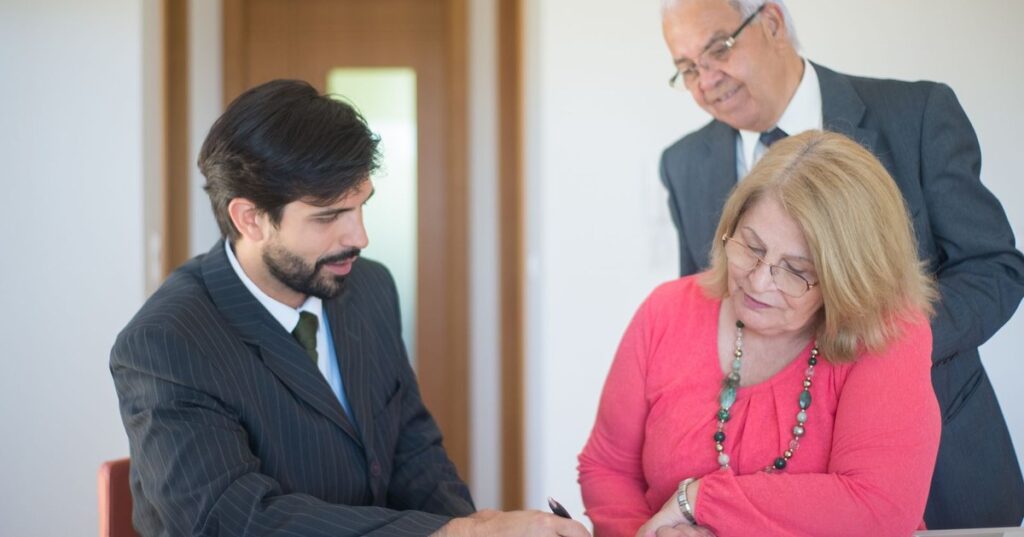 Casal de herdeiros assinando documentos de inventário com advogado em escritório