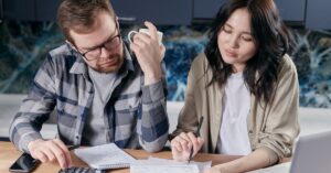 Casal analisando contrato bancário e contas para verificar juros abusivos