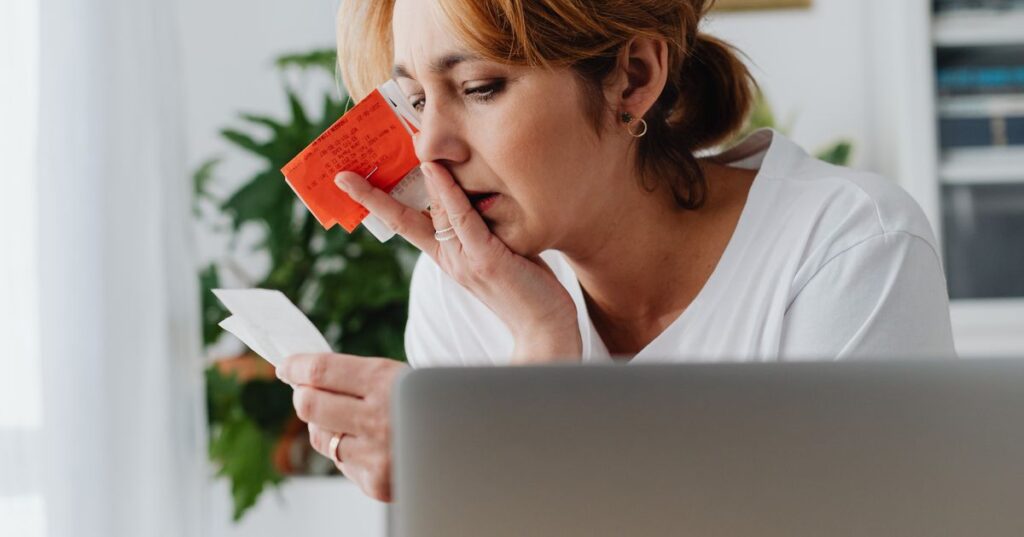Mulher adulta preocupada analisando faturas e contas do cartão de crédito