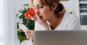 Mulher adulta preocupada analisando faturas e contas do cartão de crédito