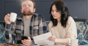 Casal adulto revisando contas e documentos financeiros sobre a mesa
