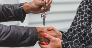 Casal recebendo a chave de um imovel financiado apos negociacao