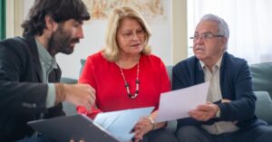 Casal de herdeiros adultos analisando documentos de inventario com advogado