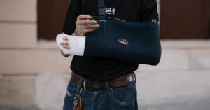 Adulto com o braço lesionado, ilustrando sequela que gera direito ao auxílio-acidente do INSS