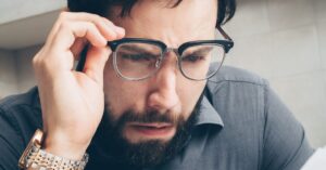 Homem adulto preocupado revisando documentos financeiros e dívidas