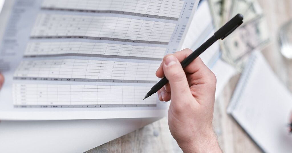 Pessoa revisando tarifas e cobranças de um contrato bancário