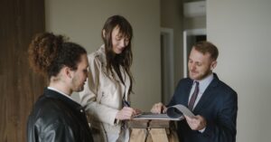 Casal adulto revisando contrato de compra de imóvel com corretor