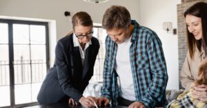 Profissional explicando documentos de compra de imóvel a um cliente adulto