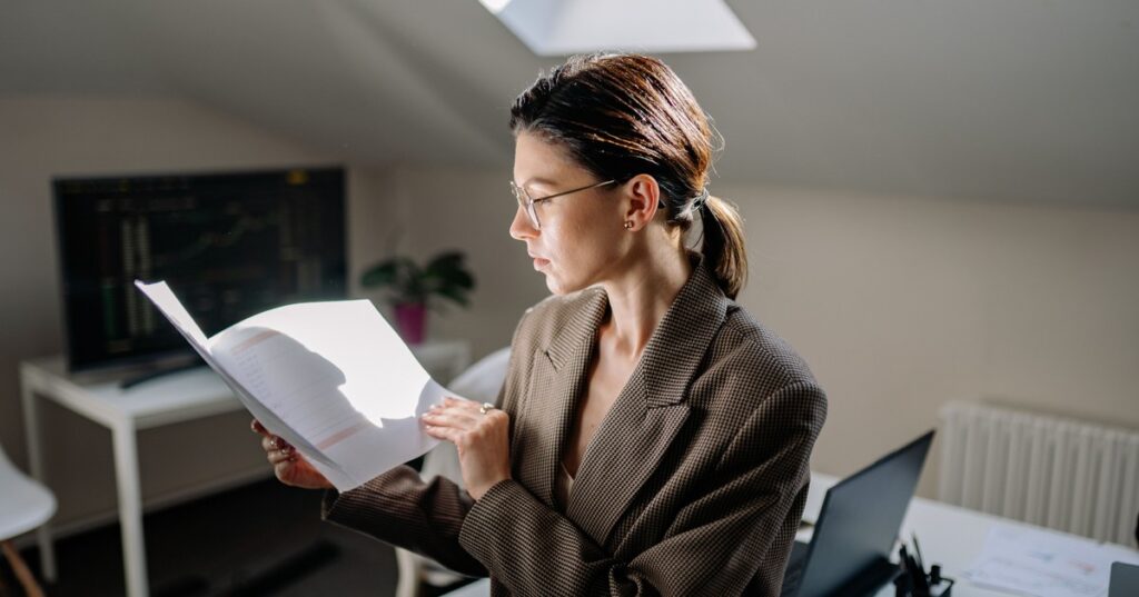 Mulher adulta revisando documentos de contrato e apólice de seguro